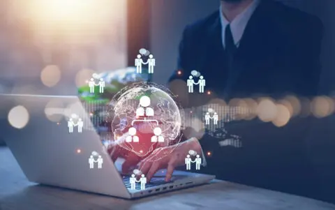 Geschäftsmann vor Laptop arbeitet mit CRM und AI Tools